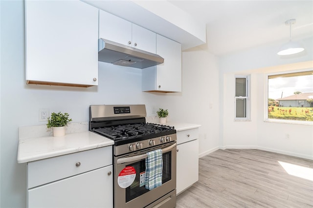 15 Bunker Pl, Rotonda West, FL 33947 - kitchen with gas range, under cabinet range hood, light wood-style floors, light countertops, and white cabinets