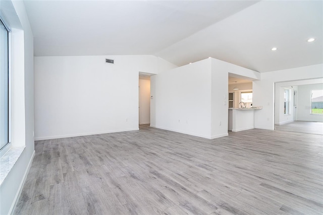 15 Bunker Pl, Rotonda West, FL 33947 - unfurnished living room with light wood finished floors, lofted ceiling, and recessed lighting