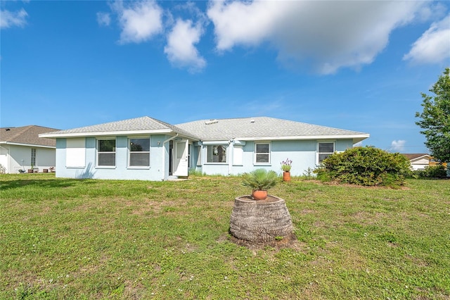 15 Bunker Pl, Rotonda West, FL 33947 - back of house with stucco siding and a lawn