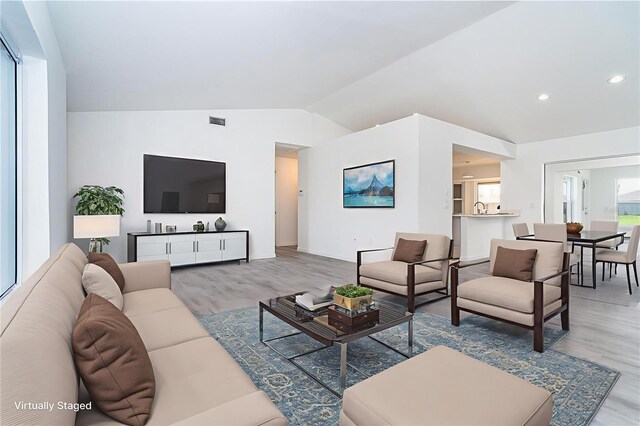 15 Bunker Pl, Rotonda West, FL 33947 - living room featuring vaulted ceiling, light wood-type flooring, and recessed lighting