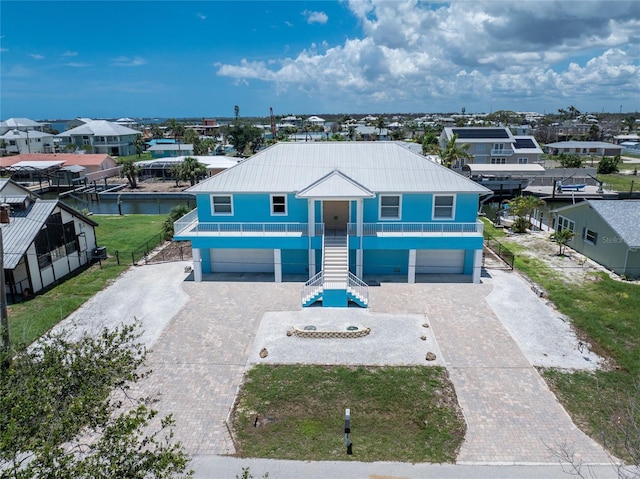1930 Massachusetts Ave, Englewood, FL 34224 - view of front facade featuring a garage, stairs, decorative driveway, and a metal roof