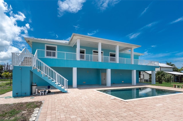 1930 Massachusetts Ave, Englewood, FL 34224 - rear view of property with a patio, an outdoor pool, stucco siding, a standing seam roof, and stairway
