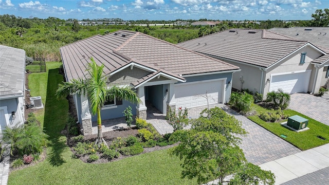 17921 Grand Prosperity Dr, Venice, FL 34293 - ranch-style home featuring stucco siding, an attached garage, decorative driveway, a tiled roof, and a front lawn