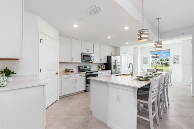 12550 Galapagos Ct Unit 104, Venice, FL 34293 - kitchen with stainless steel appliances, light tile patterned flooring, recessed lighting, white cabinets, and a center island with sink
