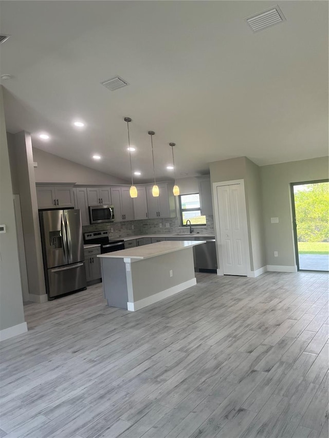 329 Overbrook St, Port Charlotte, FL 33954 - kitchen with stainless steel appliances, a center island, decorative backsplash, gray cabinets, and light countertops