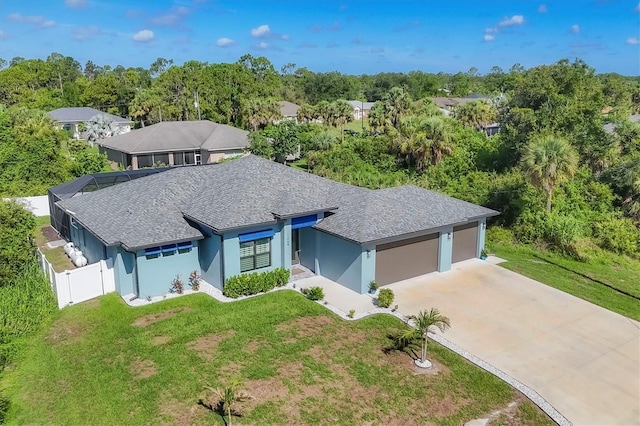 1269 N Lavina St, North Port, FL 34286 - view of front of house featuring a garage, stucco siding, concrete driveway, and roof with shingles