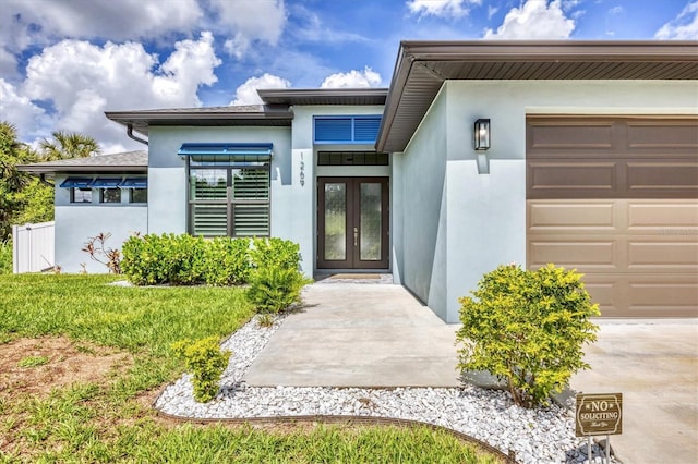 1269 N Lavina St, North Port, FL 34286 - property entrance with french doors, stucco siding, and a garage