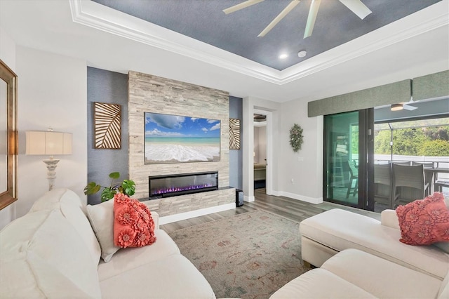 1269 N Lavina St, North Port, FL 34286 - living room with a ceiling fan, a tray ceiling, wood finished floors, a fireplace, and crown molding