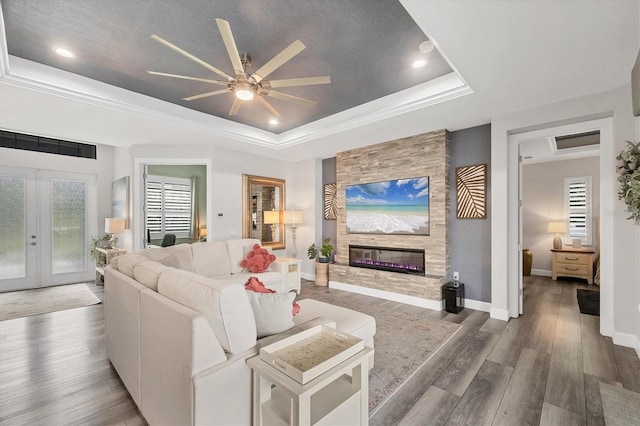 1269 N Lavina St, North Port, FL 34286 - living area featuring a tray ceiling, ceiling fan, a fireplace, wood finished floors, and french doors
