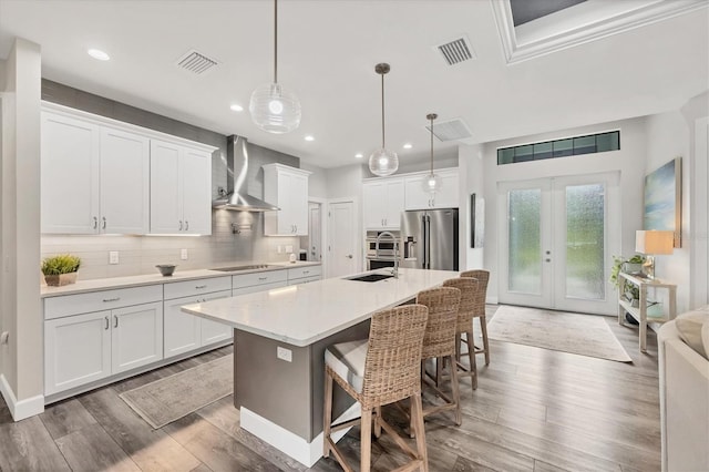 1269 N Lavina St, North Port, FL 34286 - kitchen featuring stainless steel refrigerator with ice dispenser, wall chimney range hood, wood finished floors, black electric stovetop, and recessed lighting