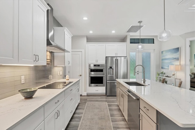 1269 N Lavina St, North Port, FL 34286 - kitchen featuring stainless steel appliances, wall chimney exhaust hood, dark wood-style flooring, white cabinets, and backsplash