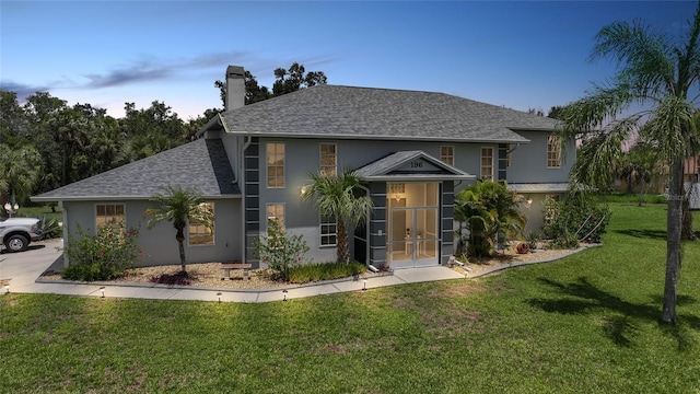 196 Lecturn St, Port Charlotte, FL 33954 - view of front of home featuring french doors, a chimney, stucco siding, a front lawn, and roof with shingles