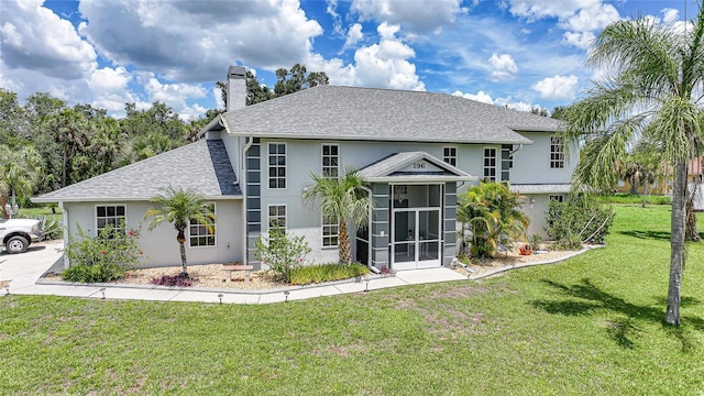 196 Lecturn St, Port Charlotte, FL 33954 - back of property with stucco siding, a chimney, a yard, a shingled roof, and a sunroom
