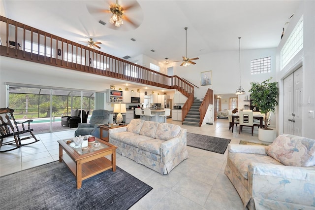 196 Lecturn St, Port Charlotte, FL 33954 - living area featuring ceiling fan, a towering ceiling, light tile patterned floors, stairs, and plenty of natural light