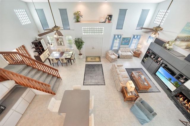 196 Lecturn St, Port Charlotte, FL 33954 - tiled living area featuring ceiling fan, a towering ceiling, healthy amount of natural light, a fireplace, and stairs