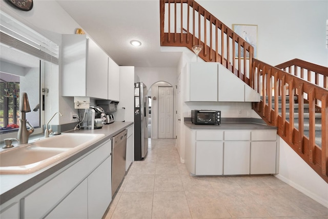 196 Lecturn St, Port Charlotte, FL 33954 - kitchen featuring stainless steel appliances, white cabinets, light tile patterned floors, arched walkways, and recessed lighting