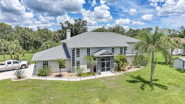 196 Lecturn St, Port Charlotte, FL 33954 - back of property featuring stucco siding, a chimney, a sunroom, a yard, and a shingled roof