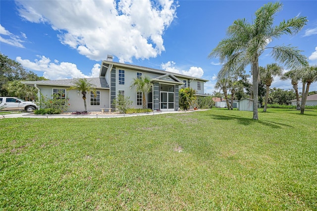 196 Lecturn St, Port Charlotte, FL 33954 - back of property with a shed, a sunroom, a lawn, stucco siding, and a chimney