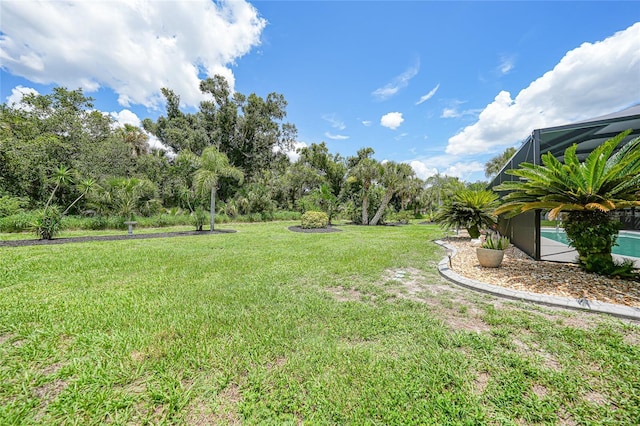 196 Lecturn St, Port Charlotte, FL 33954 - view of green lawn with an outdoor pool, a lanai, and view of wooded area