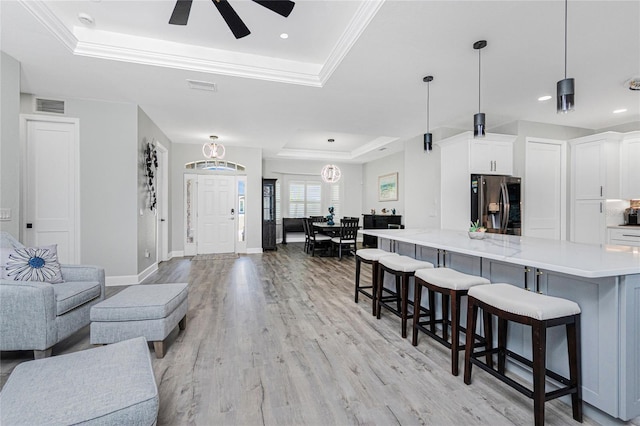 1119 Boundary Blvd, Rotonda West, FL 33947 - living area featuring a tray ceiling, light wood finished floors, ceiling fan, crown molding, and recessed lighting