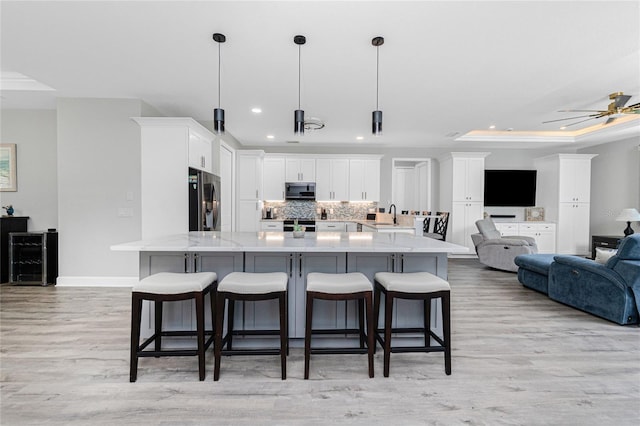 1119 Boundary Blvd, Rotonda West, FL 33947 - kitchen with stainless steel appliances, a kitchen breakfast bar, recessed lighting, decorative backsplash, and light wood-type flooring