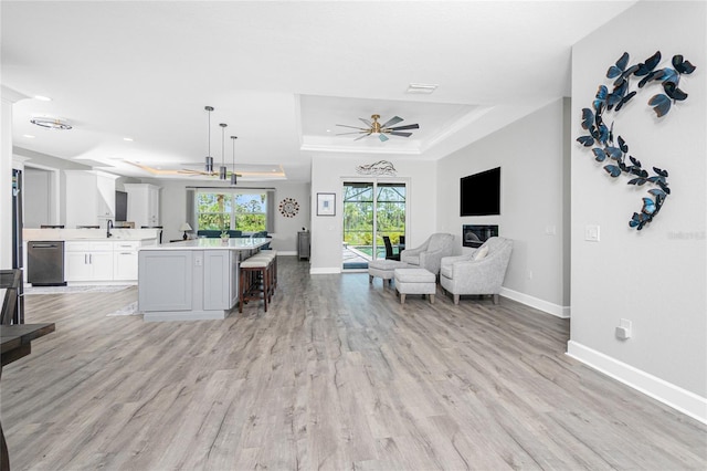 1119 Boundary Blvd, Rotonda West, FL 33947 - living room with a raised ceiling, light wood-style flooring, and ceiling fan