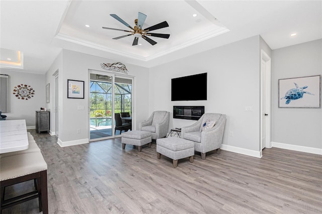 1119 Boundary Blvd, Rotonda West, FL 33947 - sitting room featuring a tray ceiling, wood finished floors, ceiling fan, recessed lighting, and ornamental molding