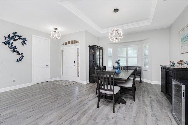 1119 Boundary Blvd, Rotonda West, FL 33947 - dining space featuring a chandelier, a tray ceiling, beverage cooler, wood finished floors, and ornamental molding