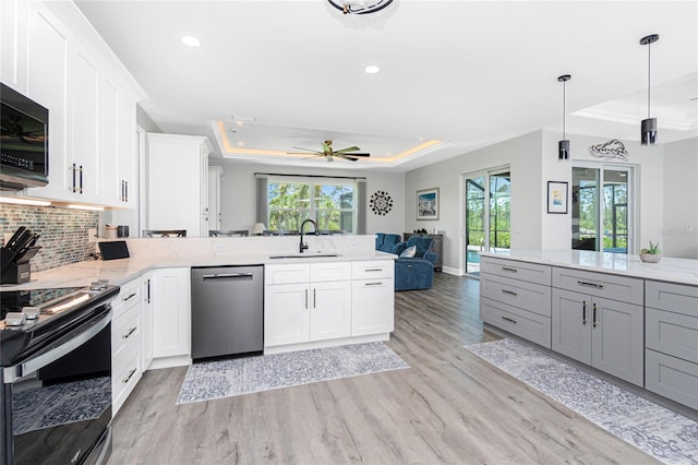 1119 Boundary Blvd, Rotonda West, FL 33947 - kitchen featuring stainless steel appliances, a raised ceiling, open floor plan, a peninsula, and plenty of natural light
