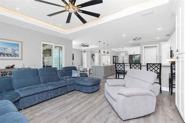 1119 Boundary Blvd, Rotonda West, FL 33947 - living room with a ceiling fan, a tray ceiling, light wood-style flooring, recessed lighting, and ornamental molding