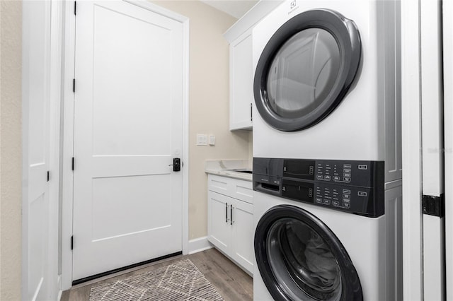 1119 Boundary Blvd, Rotonda West, FL 33947 - laundry area featuring cabinet space, stacked washer / dryer, and light wood-style floors