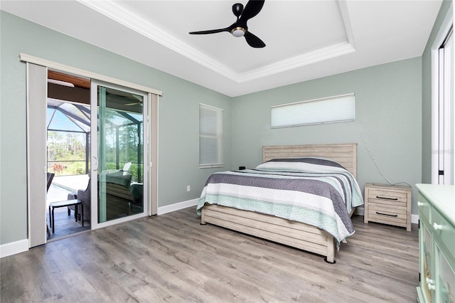 1119 Boundary Blvd, Rotonda West, FL 33947 - bedroom with a raised ceiling, access to exterior, light wood-style flooring, crown molding, and ceiling fan