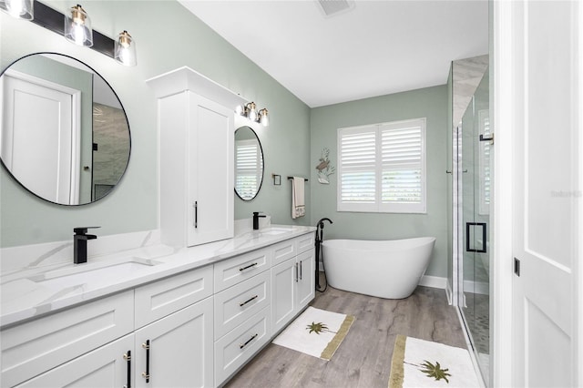 1119 Boundary Blvd, Rotonda West, FL 33947 - full bath with double vanity, a freestanding bath, wood finished floors, and a stall shower