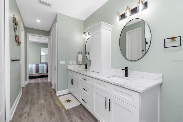 1119 Boundary Blvd, Rotonda West, FL 33947 - ensuite bathroom featuring double vanity, wood finished floors, and recessed lighting