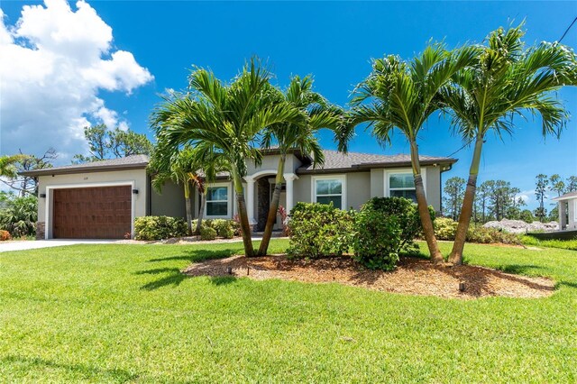 1119 Boundary Blvd, Rotonda West, FL 33947 - single story home featuring a garage, a front lawn, stucco siding, and driveway