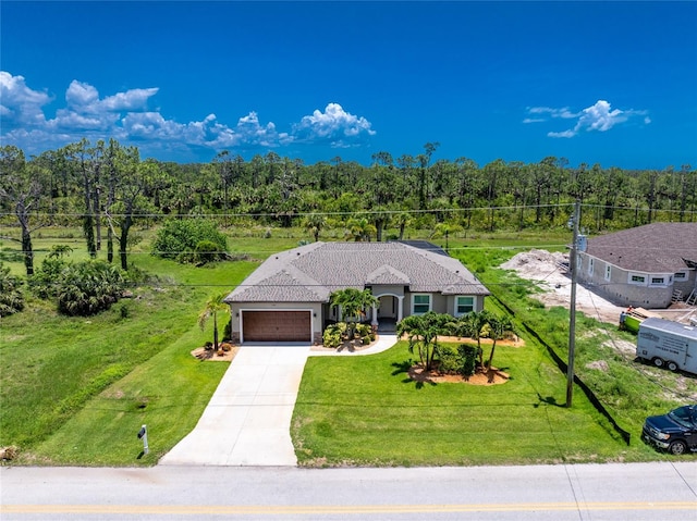 1119 Boundary Blvd, Rotonda West, FL 33947 - ranch-style home with an attached garage, concrete driveway, a wooded view, and a front yard