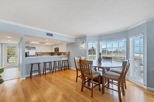 7554 Palm Island Dr S Unit 1813, Placida, FL 33946 - dining area with light wood finished floors, healthy amount of natural light, and crown molding