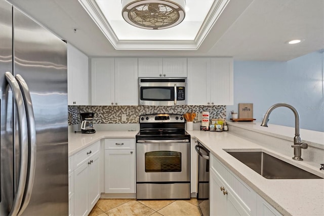 7554 Palm Island Dr S Unit 1813, Placida, FL 33946 - kitchen with appliances with stainless steel finishes, a raised ceiling, backsplash, white cabinets, and recessed lighting