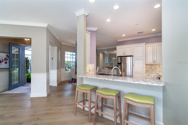 10487 Coquina Ct, Placida, FL 33946 - kitchen featuring ornamental molding, stainless steel refrigerator with ice dispenser, wood finished floors, recessed lighting, and wainscoting