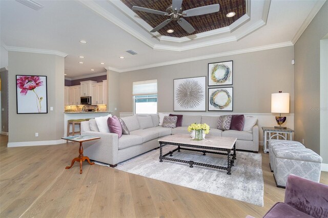 10487 Coquina Ct, Placida, FL 33946 - living room featuring a tray ceiling, light wood finished floors, ceiling fan, ornamental molding, and recessed lighting