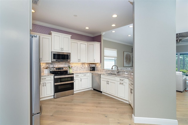 10487 Coquina Ct, Placida, FL 33946 - kitchen featuring stainless steel appliances, ornamental molding, light stone countertops, white cabinetry, and decorative backsplash
