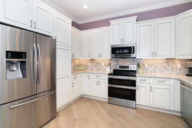 10487 Coquina Ct, Placida, FL 33946 - kitchen featuring stainless steel appliances, white cabinetry, light wood-style floors, crown molding, and light stone countertops