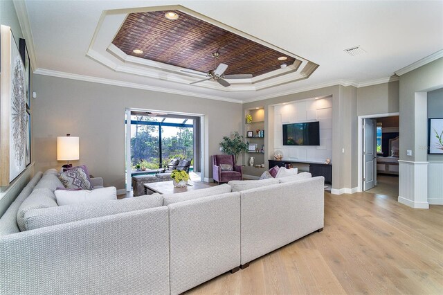 10487 Coquina Ct, Placida, FL 33946 - living room featuring a raised ceiling, light wood-style floors, crown molding, ceiling fan, and recessed lighting
