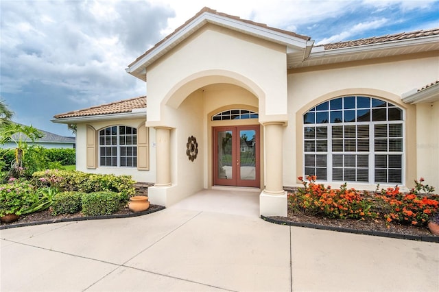 117 Abercrombie Ave, Englewood, FL 34223 - view of exterior entry featuring stucco siding, french doors, and a tile roof