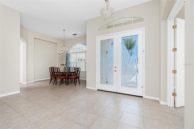 117 Abercrombie Ave, Englewood, FL 34223 - entrance foyer with a chandelier, french doors, light tile patterned floors, and arched walkways
