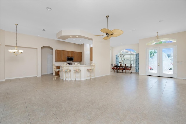117 Abercrombie Ave, Englewood, FL 34223 - unfurnished living room with a chandelier, arched walkways, french doors, light tile patterned flooring, and a ceiling fan