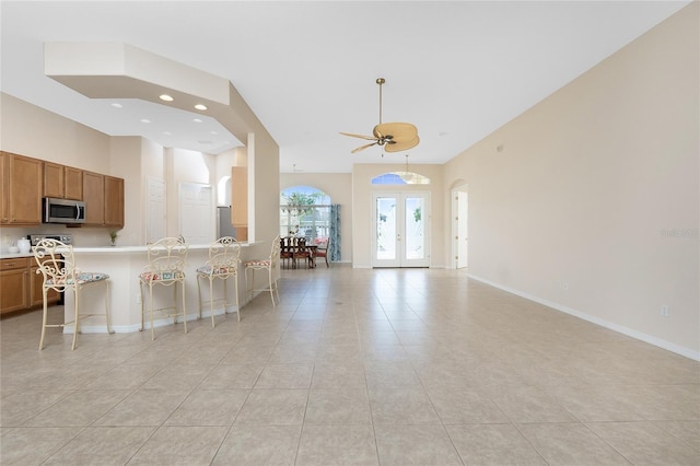 117 Abercrombie Ave, Englewood, FL 34223 - kitchen with stainless steel appliances, brown cabinetry, light tile patterned flooring, open floor plan, and recessed lighting