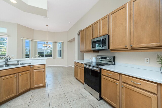 117 Abercrombie Ave, Englewood, FL 34223 - kitchen featuring appliances with stainless steel finishes, a chandelier, light tile patterned flooring, light countertops, and pendant lighting