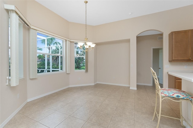 117 Abercrombie Ave, Englewood, FL 34223 - unfurnished dining area with a chandelier, arched walkways, and light tile patterned floors