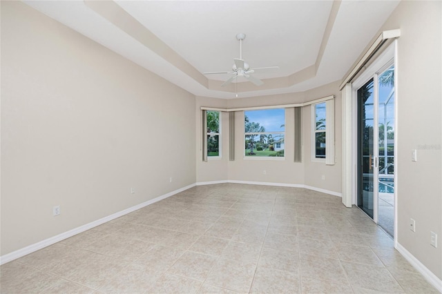 117 Abercrombie Ave, Englewood, FL 34223 - empty room with ceiling fan, a raised ceiling, and light tile patterned flooring